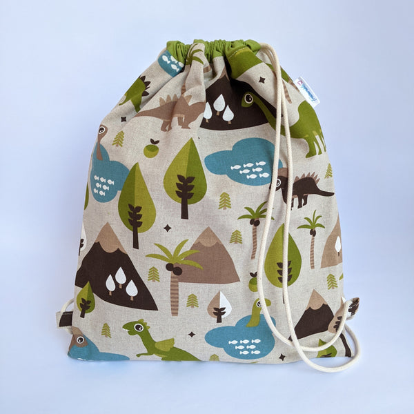 Baby dinosaur drawstring bag with green lining and natural drawcords