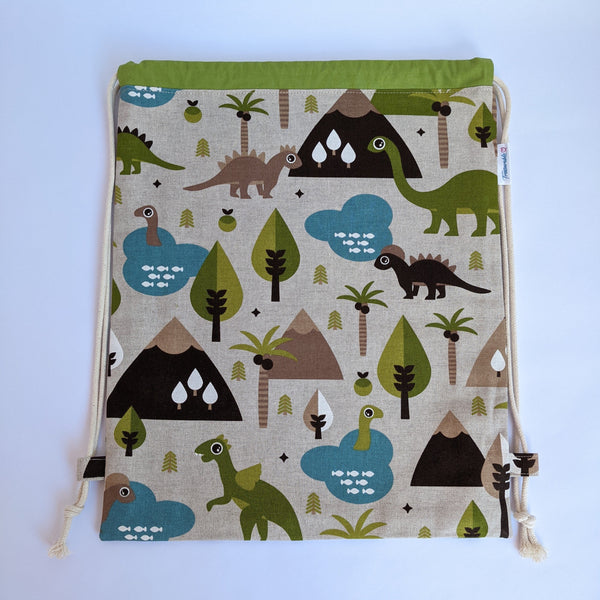 Baby dinosaur drawstring bag with green lining and natural drawcords