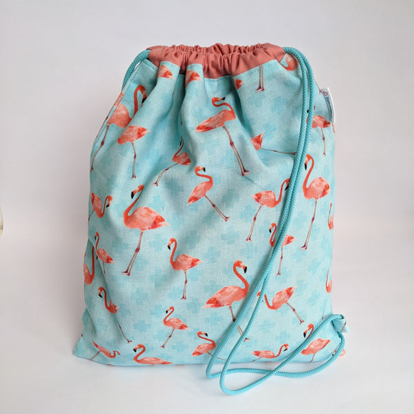 Closed coral and turquoise flamingo drawstring bag with coral lining and turquoise drawcords