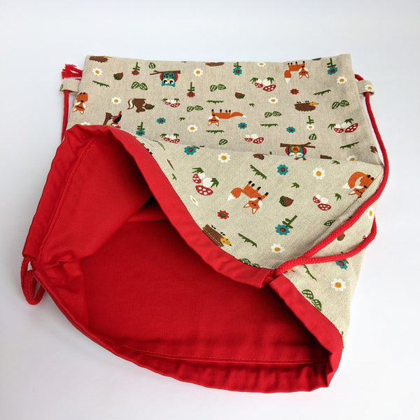 Open woodland creatures drawstring bag with red lining and drawcords