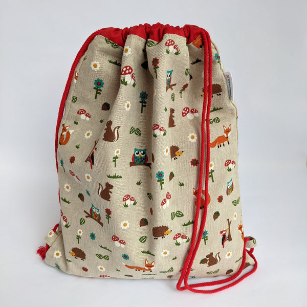 Closed woodland creatures drawstring bags with red lining and red drawcords