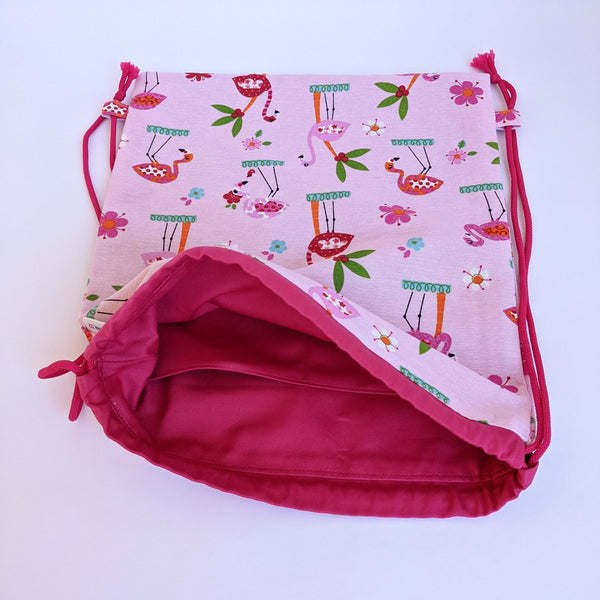 Open Flamingo and palm tree drawstring bag with dark pink lining and drawcords. Two internal pockets