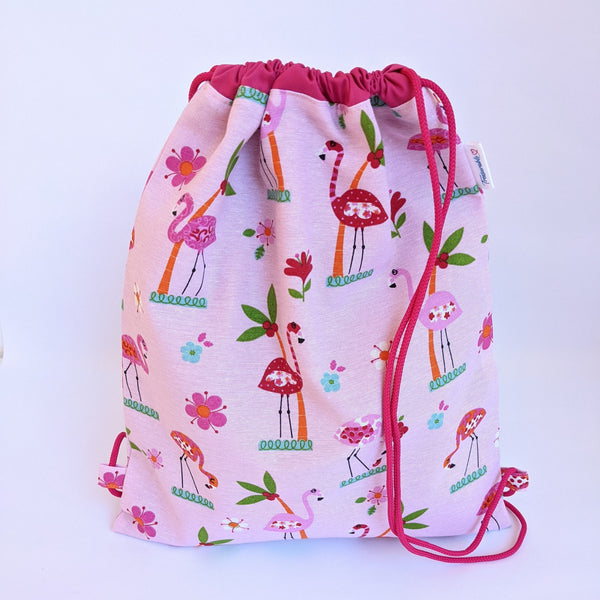 Closed flamingo and palm tree drawstring bag with dark pink lining adn drawcords