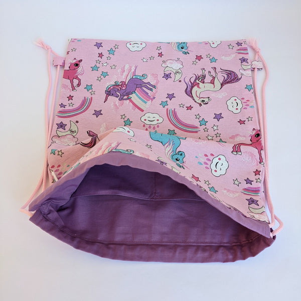 Open Unicorn drawstring bag with purple lining and baby pink drawcords