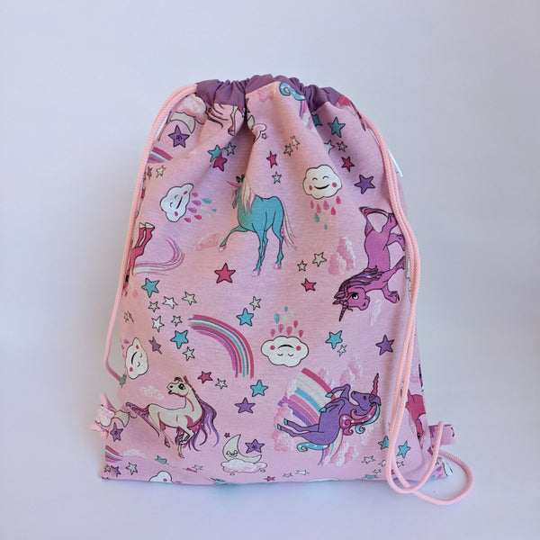 Closed Unicorn drawstring bag with purple lining and baby pink drawcords
