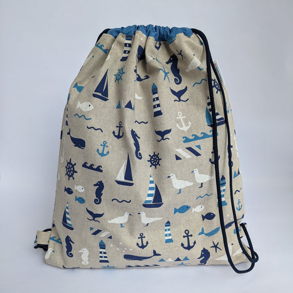 Closed Nautical drawstring backpack with medium blue lining and navy drawcords