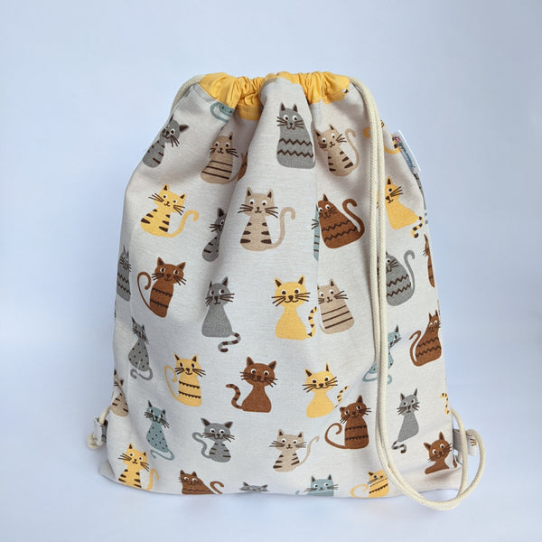 Closed Classic Cats Drawstring backpack with corn yellow lining and natural drawcords