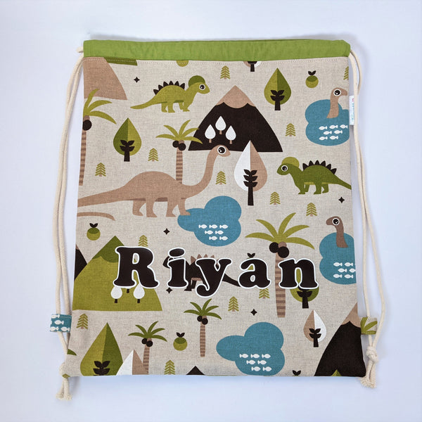 Personalised (with name) baby dinosaur drawstring bag with green lining and natural drawcords
