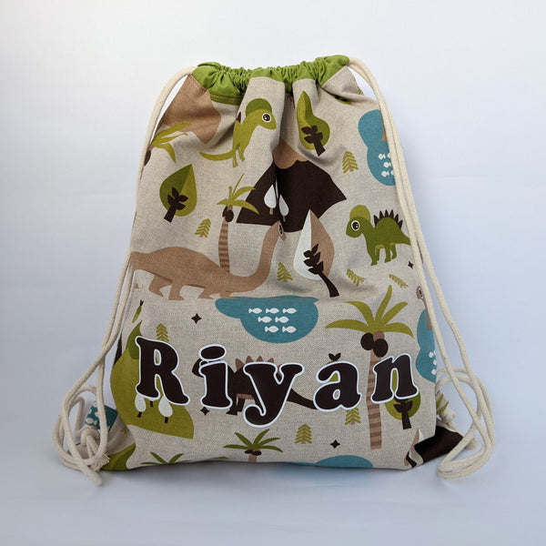 Personalised (with name) baby dinosaur drawstring bag with green lining and natural drawcords