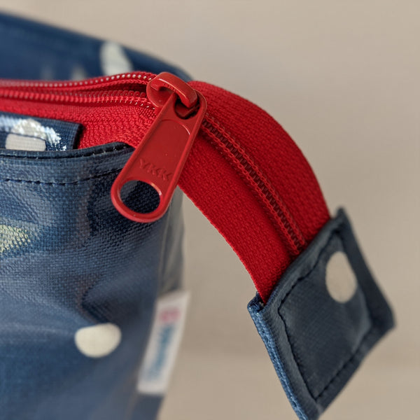 Close up of YKK zip, with long pull for ease of use. Featured on Demin Blue, Large Oilcloth Shoulder bag with recessed red zip and Cotton Webbing handles