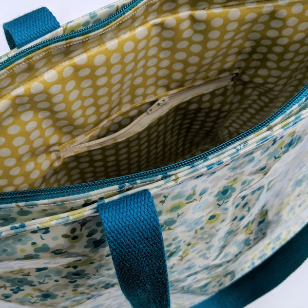 Close up view of the inside of Large Teal Floral Oilcloth Shoulder Bag with Teal Cotton Webbing Handles and Recessed Zip. Internal Zip and Open Pockets